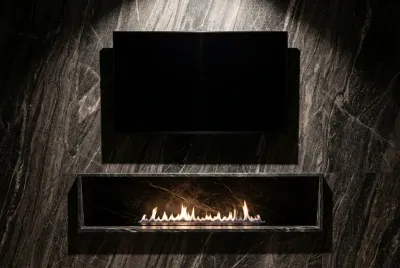 Gros plan minimaliste d'une cheminée moderne installée juste en dessous d'une télévision sur un mur design.