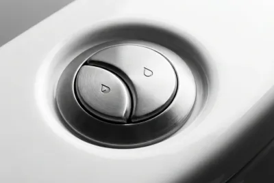 Gros plan sur un bouton de chasse d'eau moderne à double flux, alternative écologique au WC à pas rapide.
