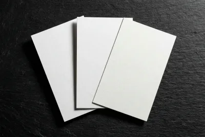 Trois nuanciers de peinture blanche RAL (9003, 9010, 9016) disposés en éventail sur un fond sombre pour un contraste élevé.