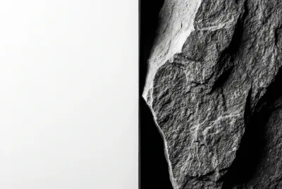 Gros plan sur la jonction entre un enduit blanc lisse et un mur en pierre texturée, mettant en évidence le contraste des matériaux.